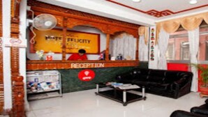 A reception area with a reception desk, a fan, a sofa, and a refrigerator. - MeroStay 191 Hotel City Pvt. Ltd. (Kathmandu)