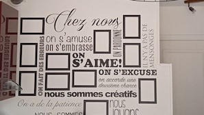 A kitchen with a wall decal featuring motivational French phrases, a red blender, a white coffee maker, and a wicker pendant light. - Cabellou Vras (Concarneau)