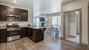Una cocina moderna con armarios de madera oscura, electrodomésticos de acero inoxidable y una isla central.