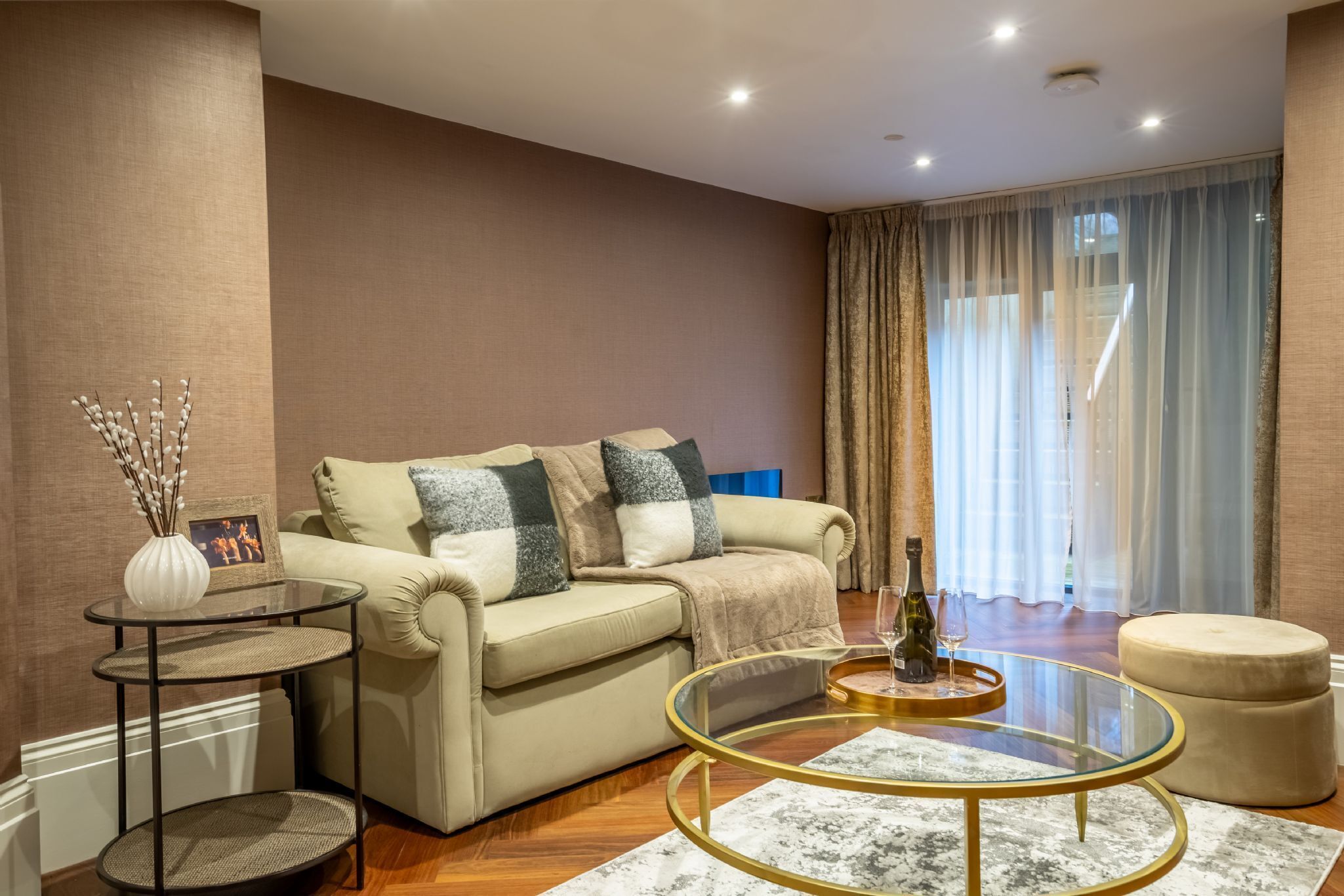A modern living room with a beige sofa, a glass coffee table, and a decorative vase.