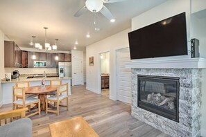 A modern kitchen with a dining area, a fireplace, and a flat-screen TV. - Clearwater Lofts Luxury 1 Bed Condo Near Lakeside Village (Keystone)