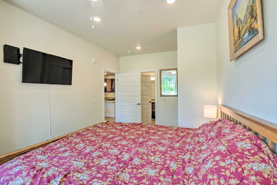 Ein Schlafzimmer mit einem Bett, einer Tür zu einem Badezimmer und einem Gemälde an der Wand.