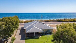 A house with a sloped roof, a covered porch, and a view of the ocean. - The Dunes *Pet Friendly* Sea Retreat Busselton (Wonnerup)