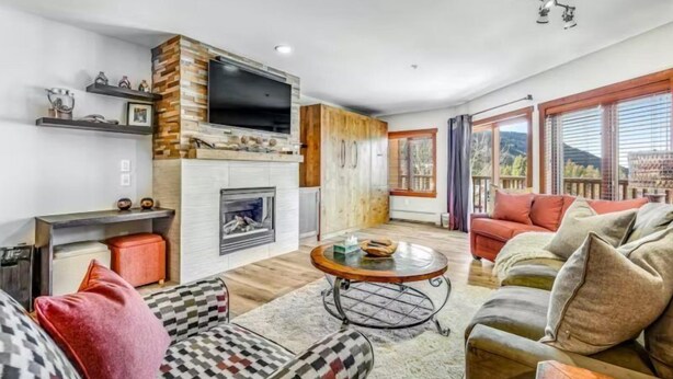 Ein modernes Wohnzimmer mit Kamin, Fernseher und einer Couch.