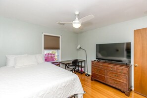 A bedroom with a bed, a desk, a dresser, a ceiling fan, and a television. - The Knotty Hooker - Classic 4BR Soundfront Home - Pet Friendly! (Surf City)