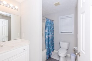 A bathroom with a white sink, mirror, and toilet. - Shore Is Nice - 4BR Townhouse with Easy Beach Access! Pet Friendly! (Surf City)