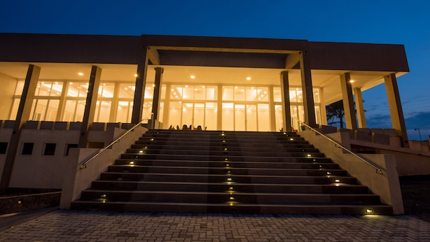 Un edificio con una escalera que conduce a un área de acceso cubierta.