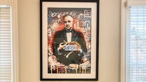 A framed poster on a wall above a glass table with a white circular object on it. - Modern en-suite Studio in the Heart of Mill Road (Cambridge)