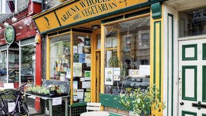 A storefront with a sign reading "Arjuna Wholefoods 100% Vegetarian." - Modern en-suite Studio in the Heart of Mill Road (Cambridge)