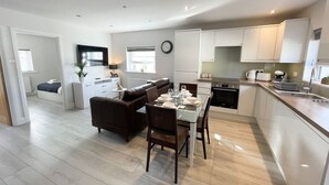 A modern apartment with a dining area, kitchen, and living room. - Centrally located 2 bedroom Apartment near Station (Cambridge)