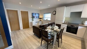 A modern apartment with a dining area, kitchen, and living space.