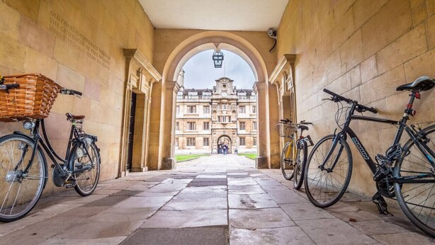A corridor with a large arched doorway leading to a historic building.