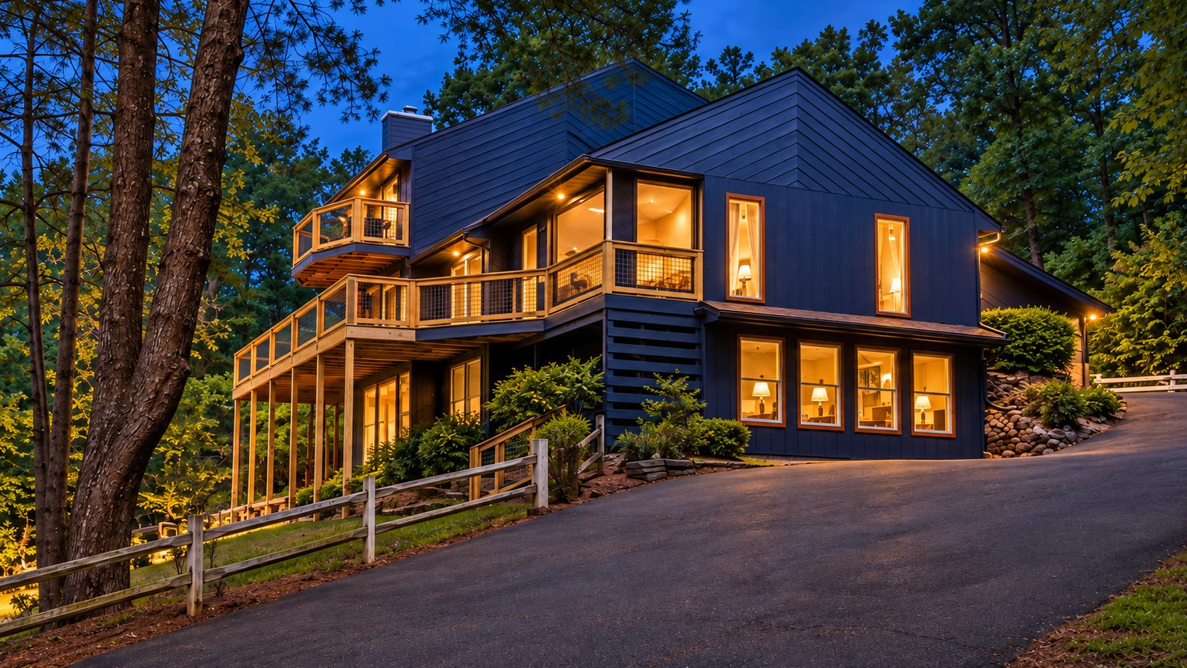 A two-story house with a balcony, a driveway, and a well-maintained lawn.