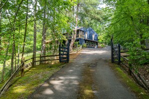 A pathway leading to a blue house surrounded by trees. - Stunning Luxury Retreat With Sweeping Mountain Views!  Something for Everyone! (Gatlinburg)