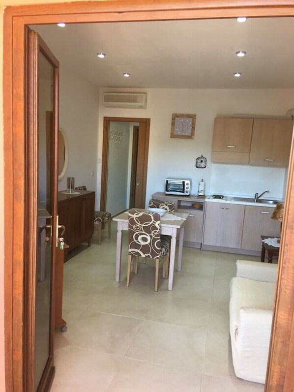 A compact living space with a dining area, kitchenette, and a small seating area.
