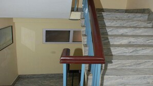 A staircase with marble steps and a wooden handrail. - MeroStay 192 Home HTS (Kathmandu)