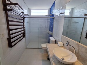 A modern bathroom with a shower, toilet, and sink.
