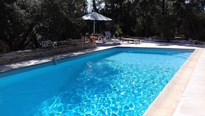 A rectangular swimming pool with clear blue water, surrounded by a stone wall and a tiled deck. - Prestigious South-Facing Villa with Pool – Absolute Calm on the French Riviera (Le Muy)