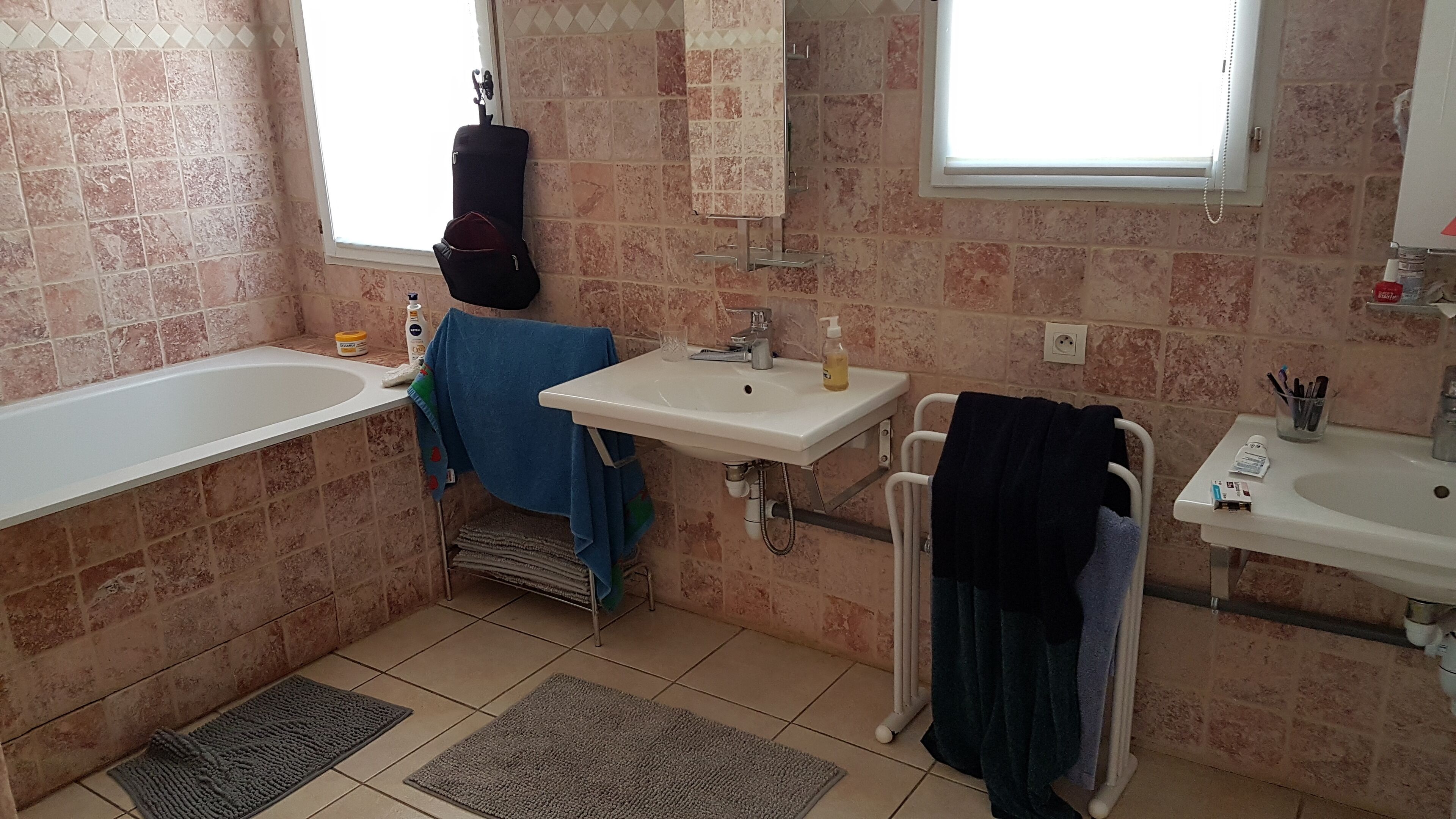 Un baño con bañera, lavamanos, espejo y ventana.