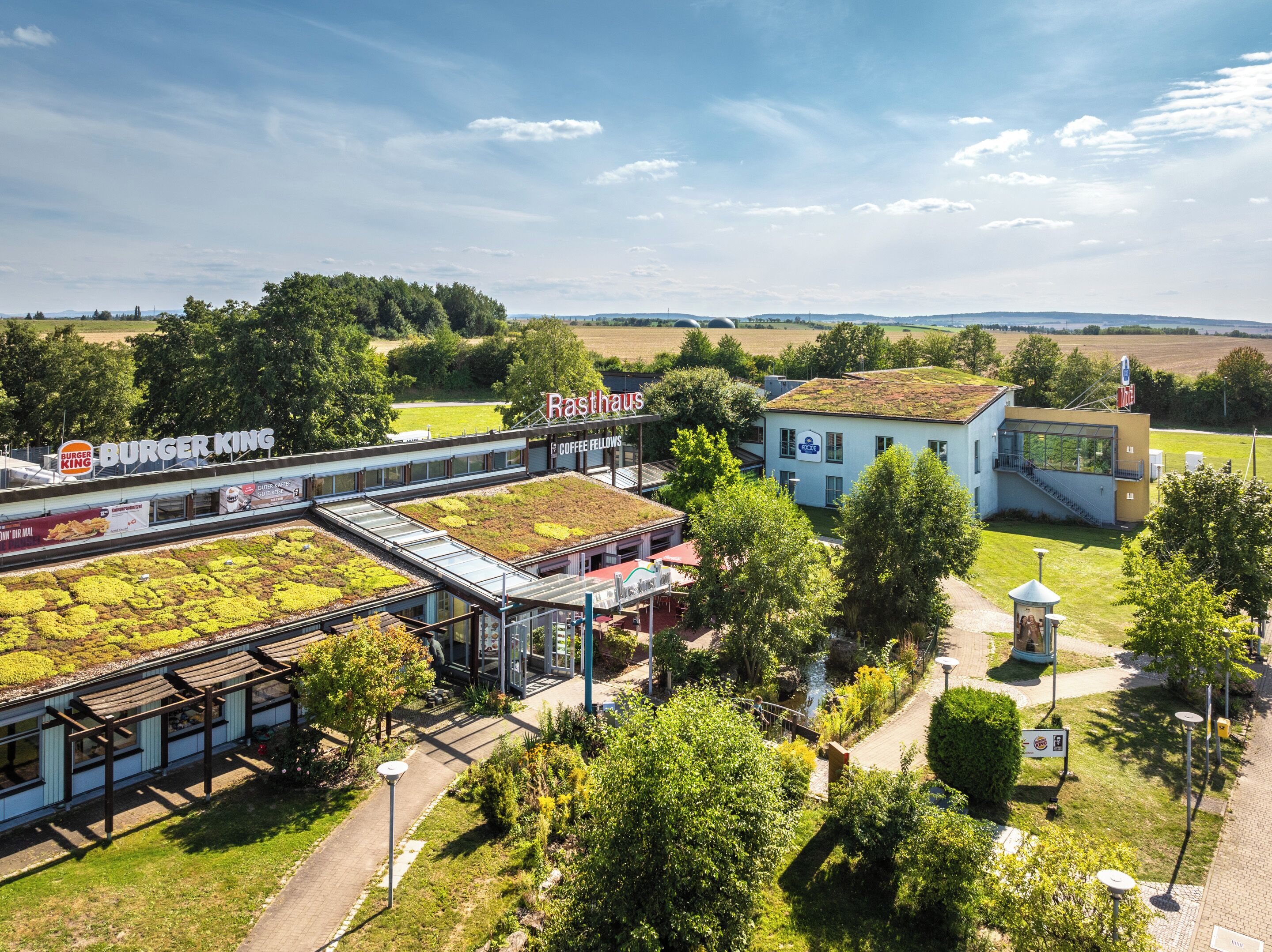A restaurant with a green roof and a Burger King sign.