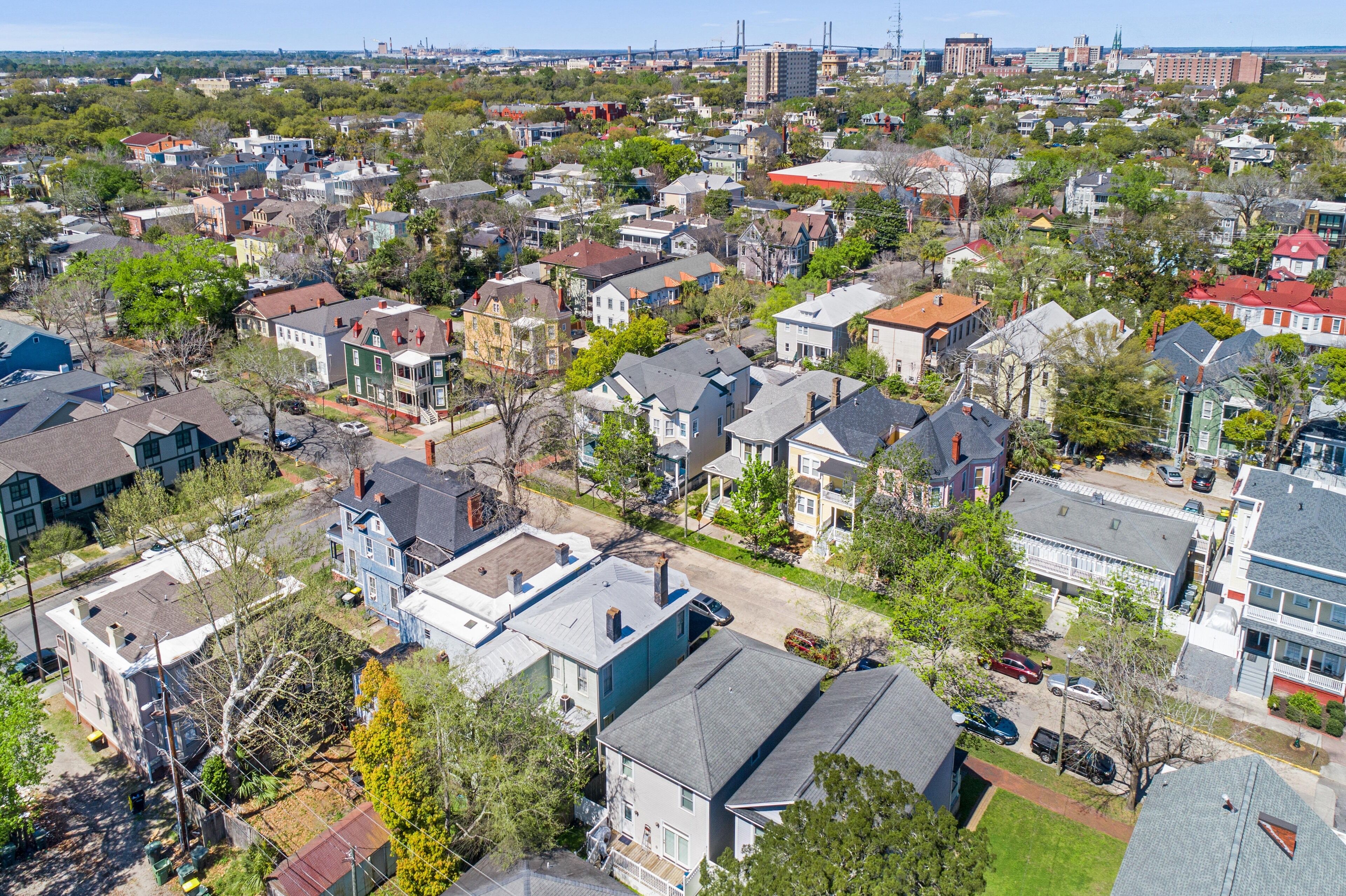 A residential area with houses, trees, and a clear sky.