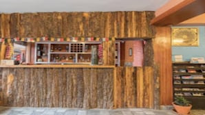 Un área de recepción con un muro de madera, un mostrador con diversos objetos y una pequeña estructura de ladrillo.