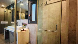 A modern bathroom with a glass shower enclosure, a sink with a mirror, and a towel rack.
