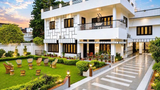 A modern two-story building with a courtyard, outdoor seating, and a well-maintained garden. - Dhairya Villa Home Away From Home (Jammu)