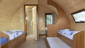 Una cabaña con dos literas, una mesita y una ventana.