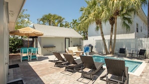 A poolside area with lounge chairs, a small pool, and a white fence. - Tranquil Retreat by the Beach-4 bedroom 3 bath home w/private pool, parking (Key West)
