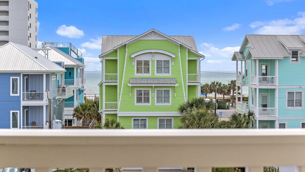 A coastal building with a green facade, multiple windows, and balconies. - Lemoncello | Spacious for a Group, Elevator Access + Partial Ocean Views (Carolina Beach)