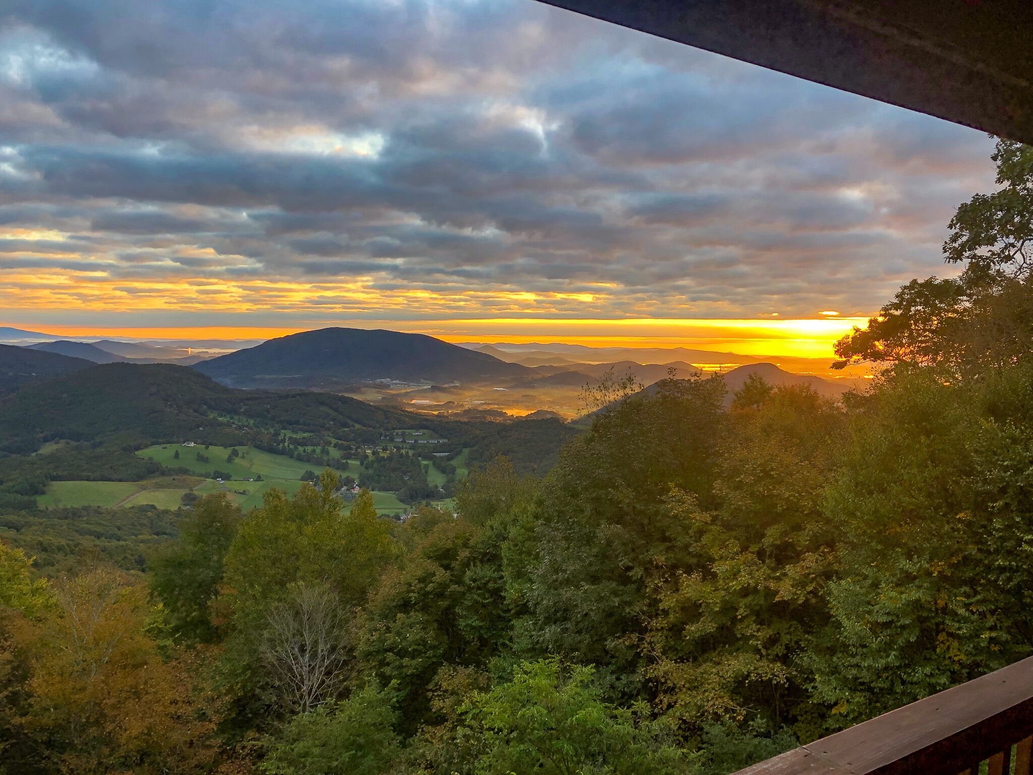 A scenic view of a mountainous landscape with a sunset.