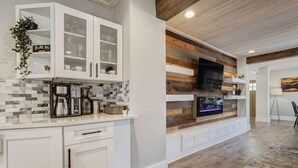 A modern kitchen with white cabinetry, a built-in microwave, and a stone backsplash. - Hot Tub and Firepit Gazebo Pikes Peak Sunset Views (Colorado Springs)