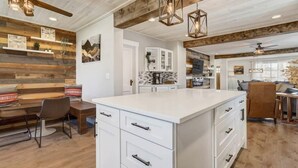 A spacious kitchen with a large island, wooden beams on the ceiling, and pendant lighting. - Hot Tub and Firepit Gazebo Pikes Peak Sunset Views (Colorado Springs)