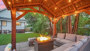 An outdoor patio with a fire feature, seating, and string lights. - Hot Tub and Firepit Gazebo Pikes Peak Sunset Views (Colorado Springs)