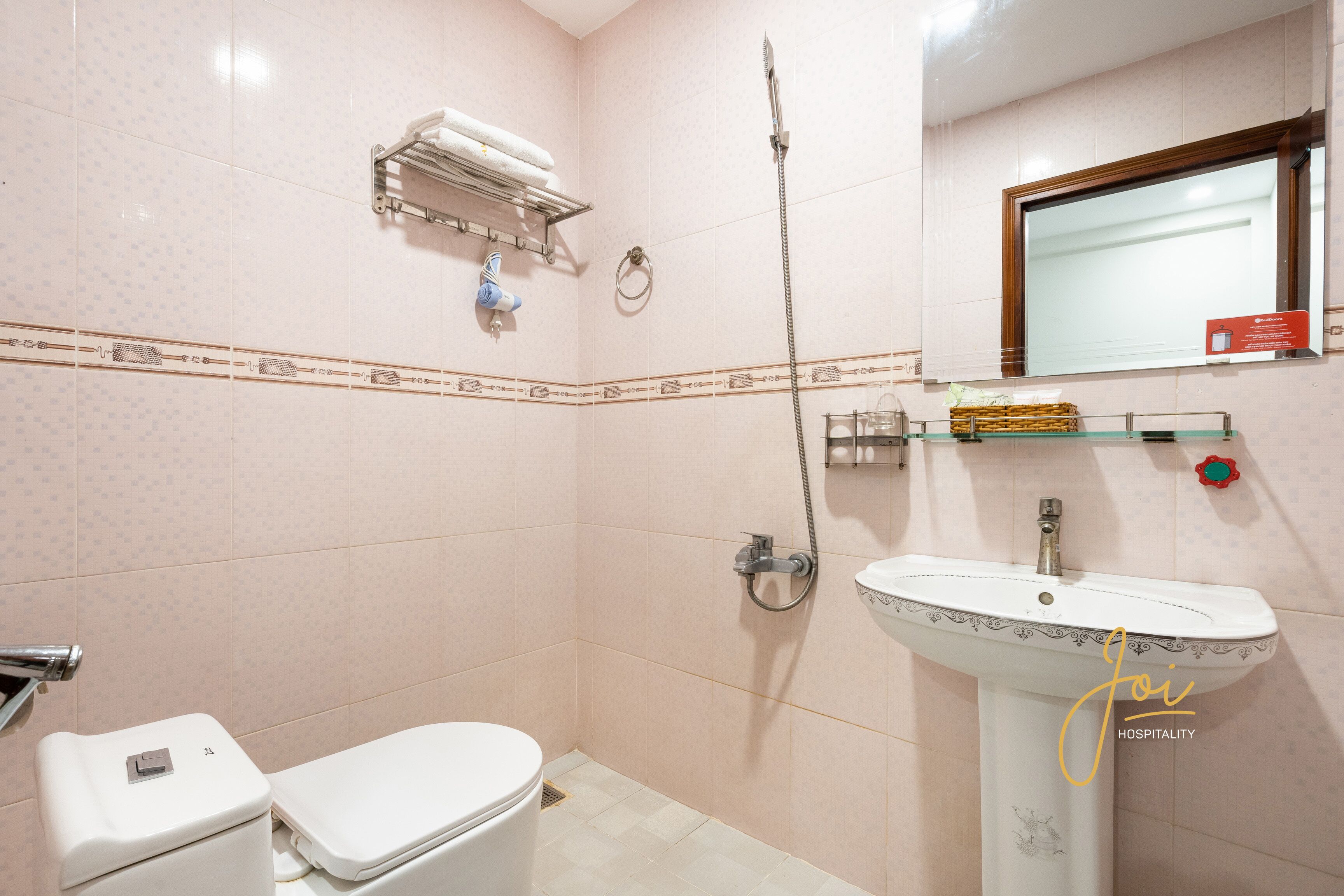 Une salle de bain équipée de toilettes, d’un lavabo, d’une douche et d’un porte-serviettes.