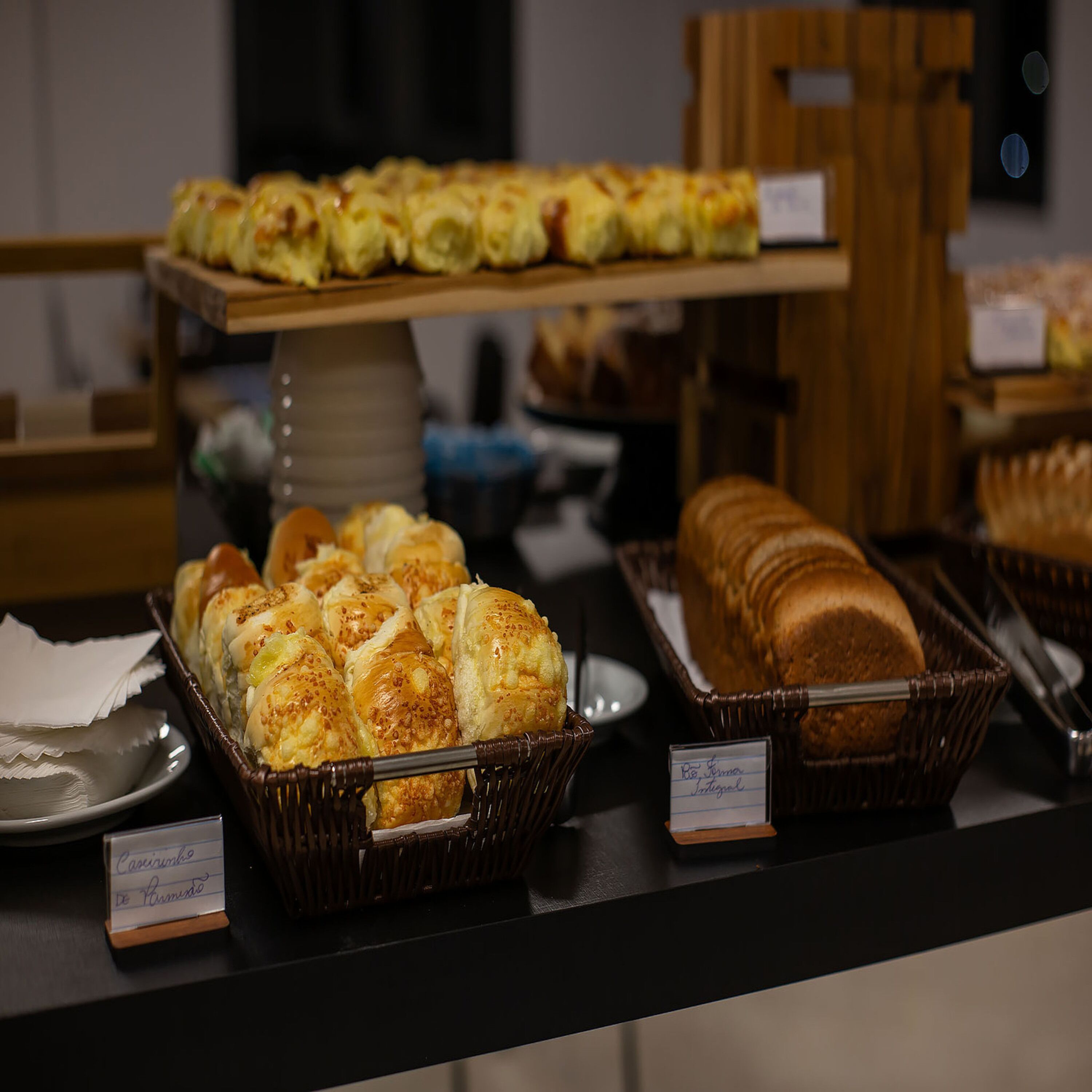 Um buffet com diversos produtos de panificação, incluindo pão e doces.