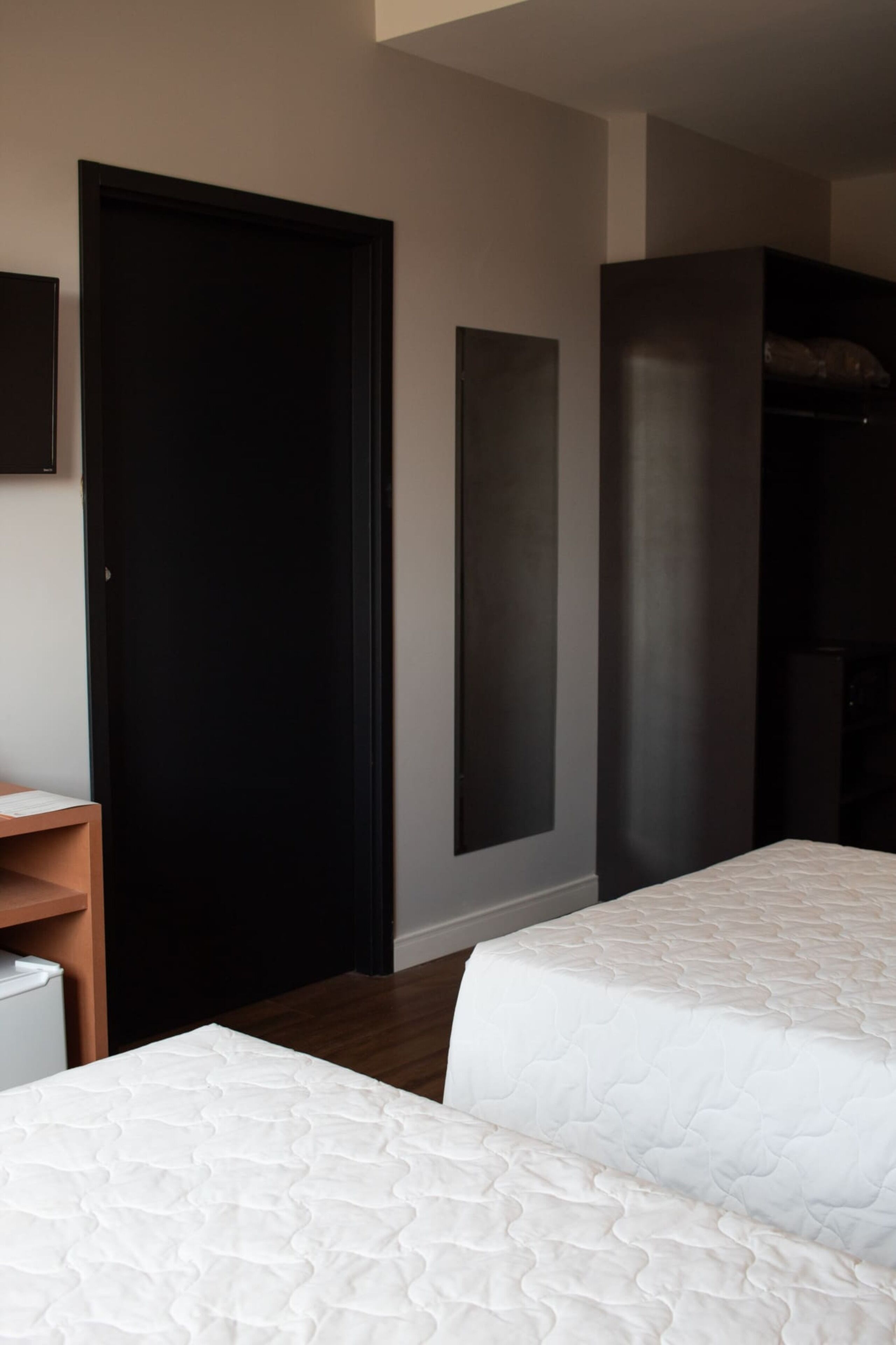 Een hotelkamer met twee bedden, een kledingkast en een zithoek.