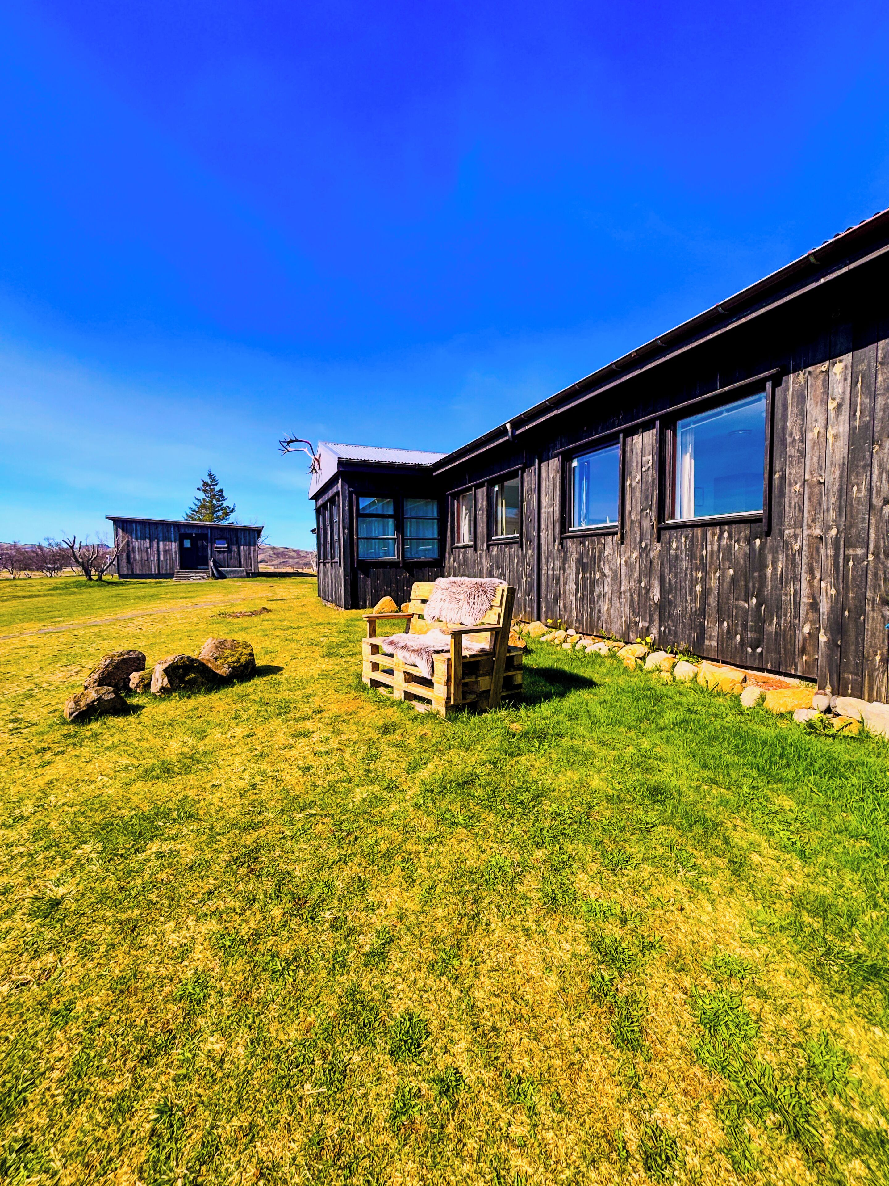 A rustic wooden building with a large window and a small porch area.