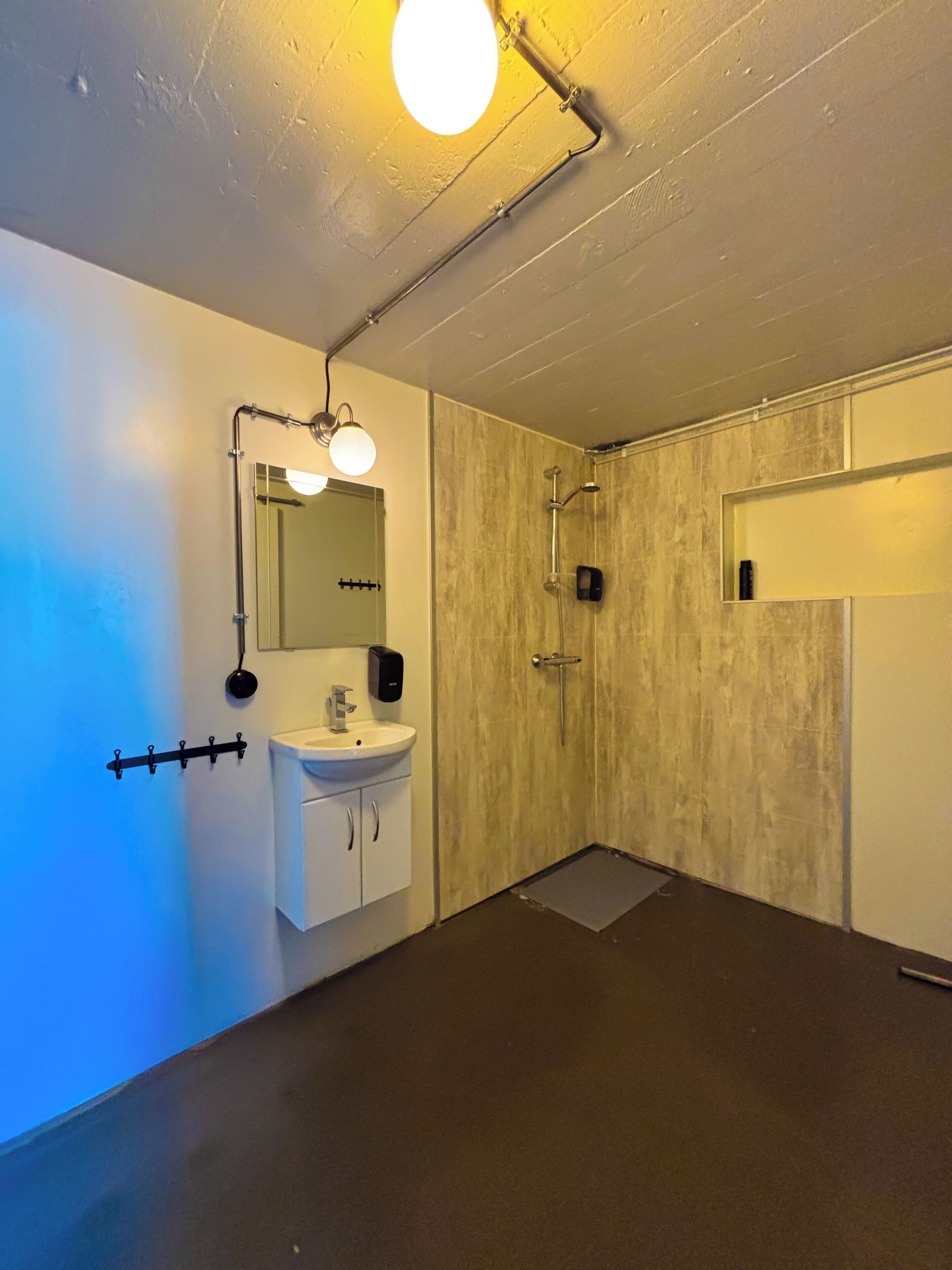 Un baño moderno con lavamanos, espejo y ducha blancos.