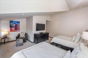 Une chambre d’hôtel avec un lit, une chaise, une télévision et un tableau au mur.