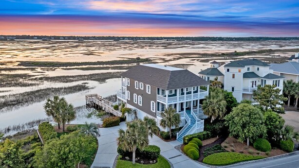 A waterfront property with a large house featuring a balcony and a dock. - Dockside Hideaway: Enjoy Privacy and Scenic Views (Wrightsville Beach)