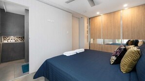 Un dormitorio con cama, ventilador de techo y armario.