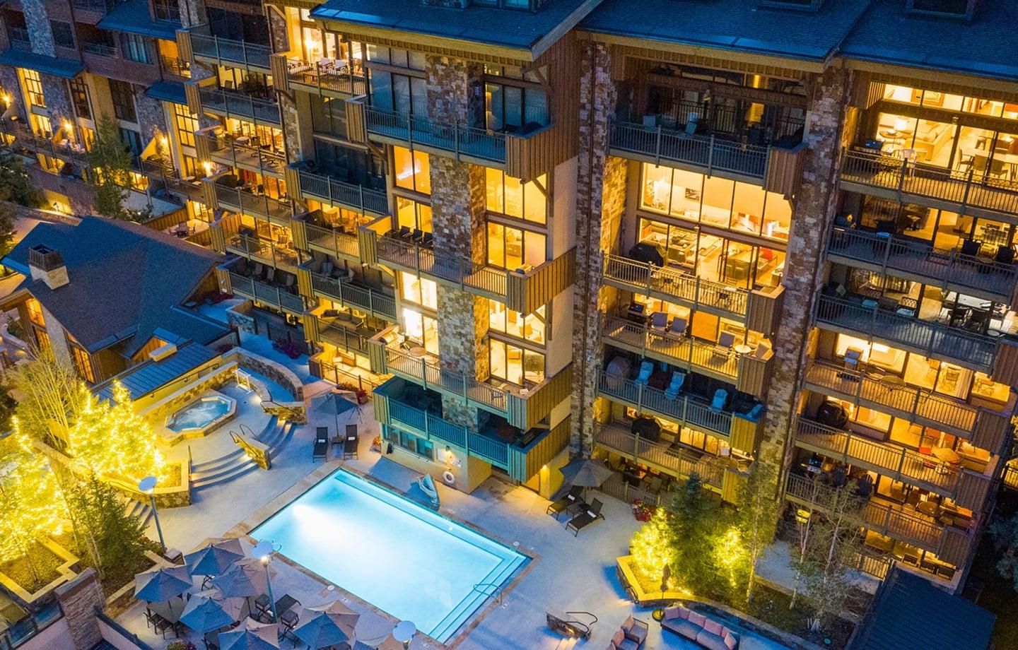 Un hôtel à plusieurs étages doté d’une piscine extérieure, d’espaces de détente et de balcons.