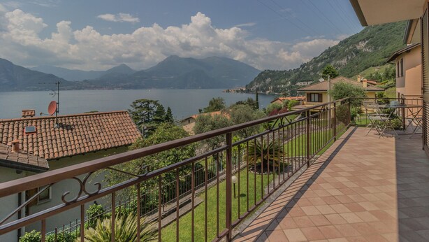 Een balkon met uitzicht op een meer en bergen.