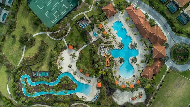 An aerial view of a resort with multiple swimming pools, a tennis court, and landscaped areas. - 4329ac - Solterra Gated Resort 5 Bedroom Home by RedAwning (Davenport)