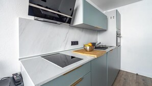 A modern kitchen with a built-in stove, a microwave, and a wooden countertop. - 100m from resort center, Ground floor, balcony, tv, ski locker, 21m², Tignes (Tignes)