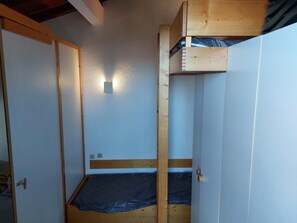 A room with a bunk bed, a door, and a wall-mounted light fixture. - 50m from ski slopes, 4th floor, view valley, balcony, tv, 35m², Les Arcs (Les Arcs)