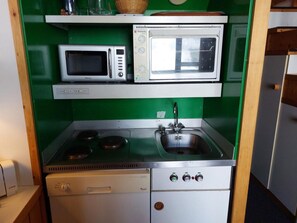 A compact kitchenette with a microwave, toaster, and stove. - 50m from ski slopes, 4th floor, view valley, balcony, tv, 35m², Les Arcs (Les Arcs)