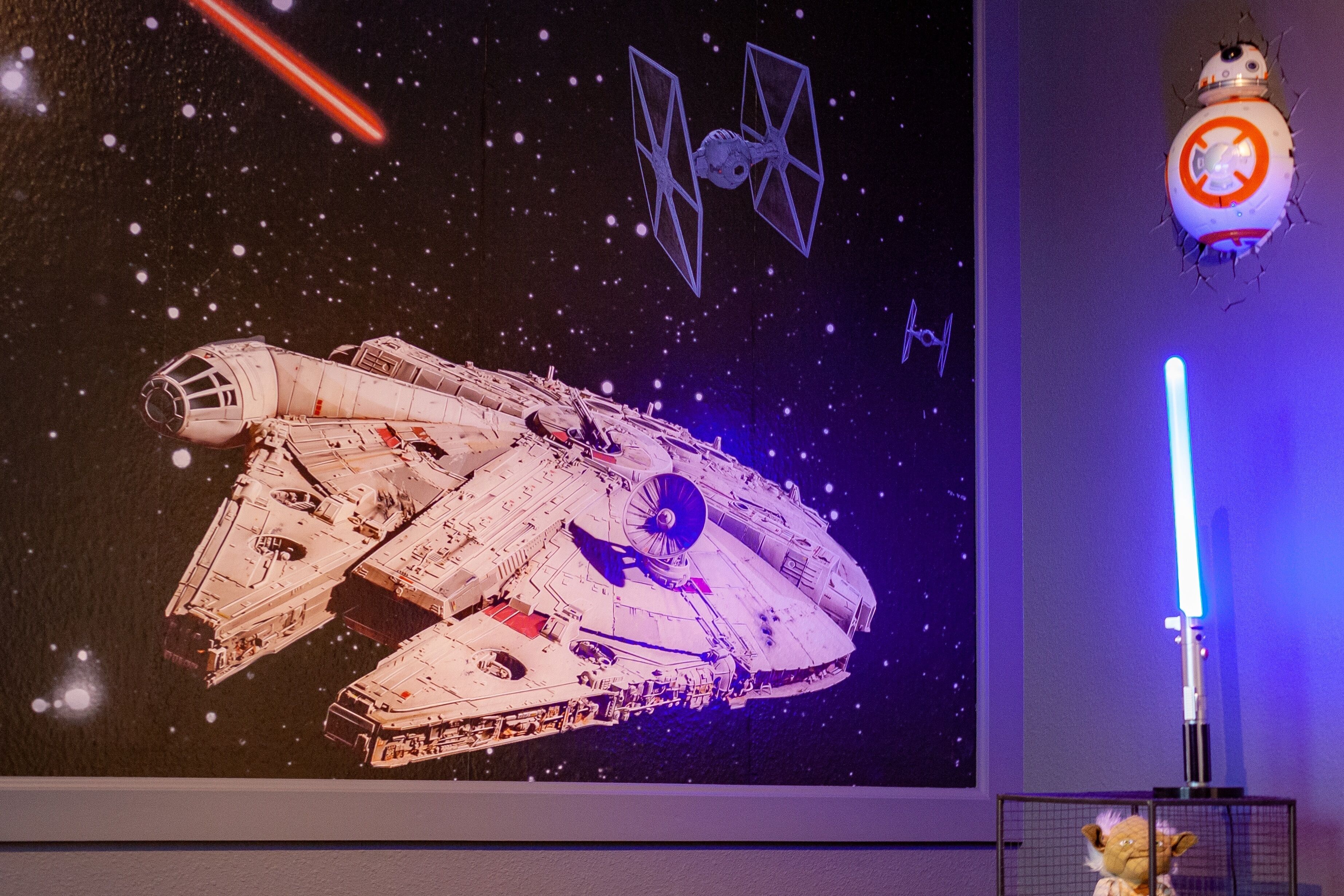 A large space-themed artwork featuring a spaceship, lightsabers, and a droid.